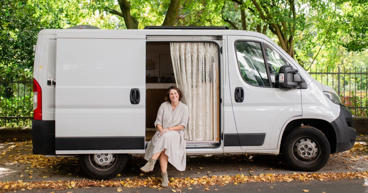 Susanne Rieker perched on the entrance to her campervan traveling in her business.